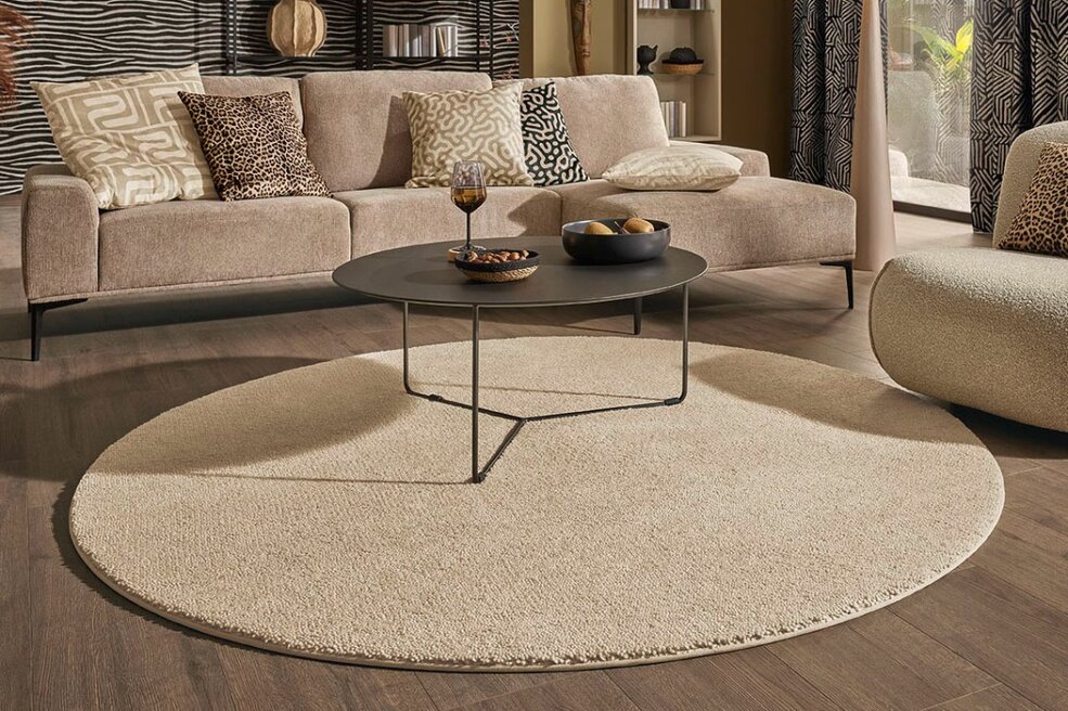 Wohnzimmer mit rundem JOKA Teppichboden Wool Vida, weiche Haptik und wohnliche Atmosphäre.