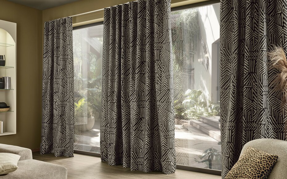 Raumbild zum Gardinenstoff KITO aus der Dekostoffkollektion Frühjahr 2026 von JOKA. Schwarz-weiß Stoff mit Muster