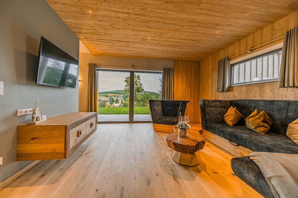 Wohnzimmer im Ferienhaus mit warmem JOKA Holzboden.