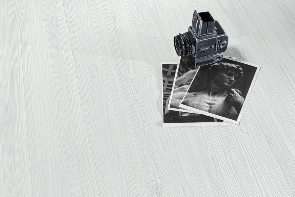 Detailaufnahme von Fotos und Schmuck auf einem weißen Holzregal im Pantone Cloud Farbton.