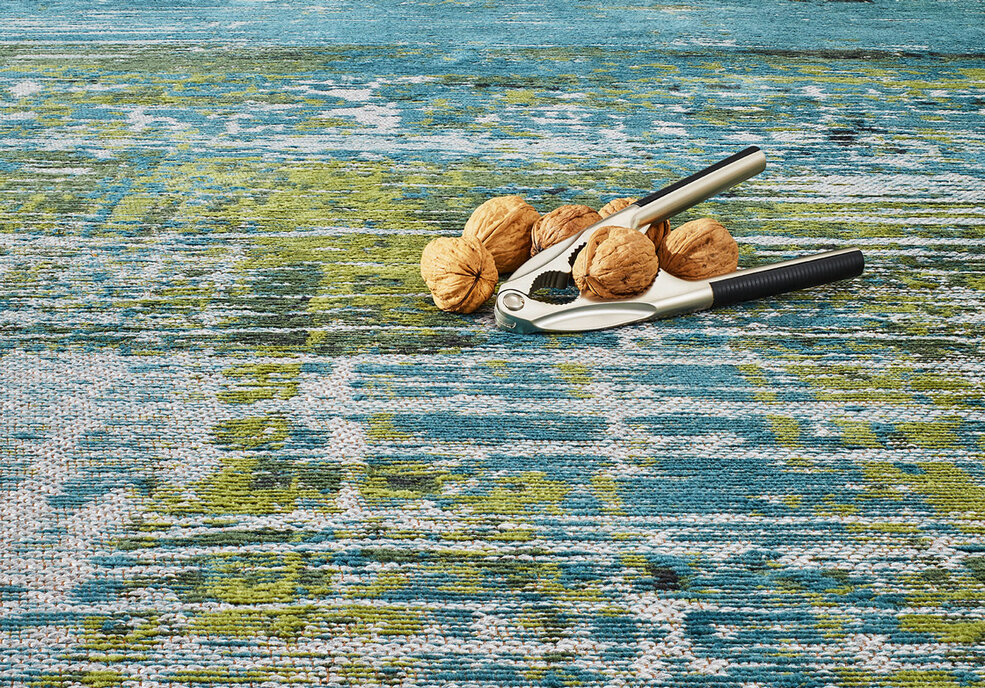 Nahaufnahme eines blau gemusterten JOKA Teppich - passend zur Raumgestaltung in der Grünanlage Wohnidee.