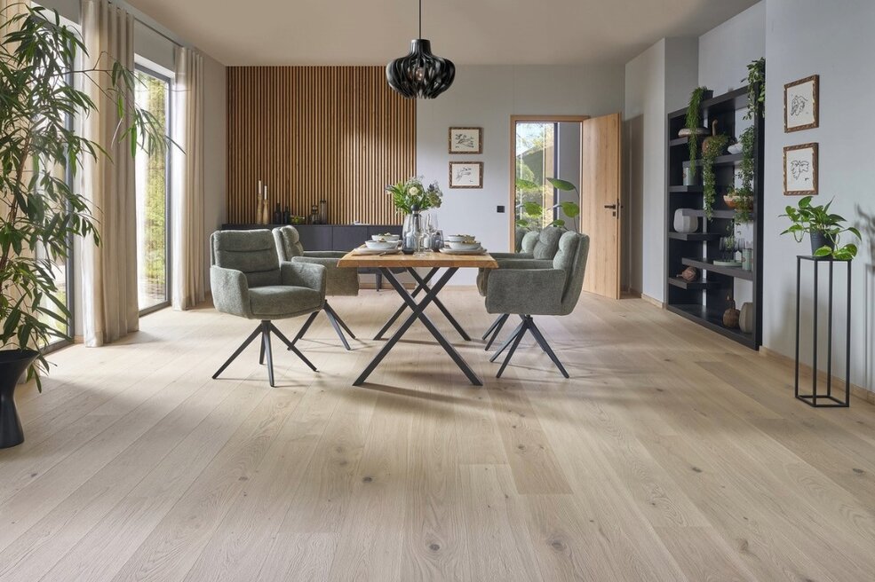 Raumbild eines Esszimmers, welches durch den grauen Naturholzboden modern und edel wirkt.