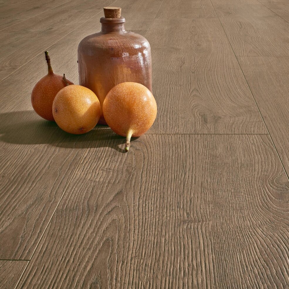 Detailaufnahme eines JOKA Laminatbodens in Holzoptik mit dekorativen Accessoires.