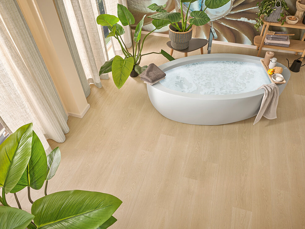 Raumbild eines Badezimmers mit Badewanne in dem ein heller Xplora NEXT Naturdesignboden verlegt ist.
