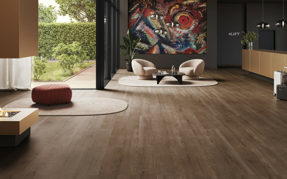 Modernes Wohnzimmer mit JOKA Designboden in dunkler Holzoptik – Ein stilvoll eingerichtetes Wohnzimmer mit großen Glasfronten, dunklem JOKA Designboden und einer auffälligen Wandgestaltung mit Kunstmotiv. Runde Sitzmöbel und ein gemütliches Ambiente ergänzen den Raum.