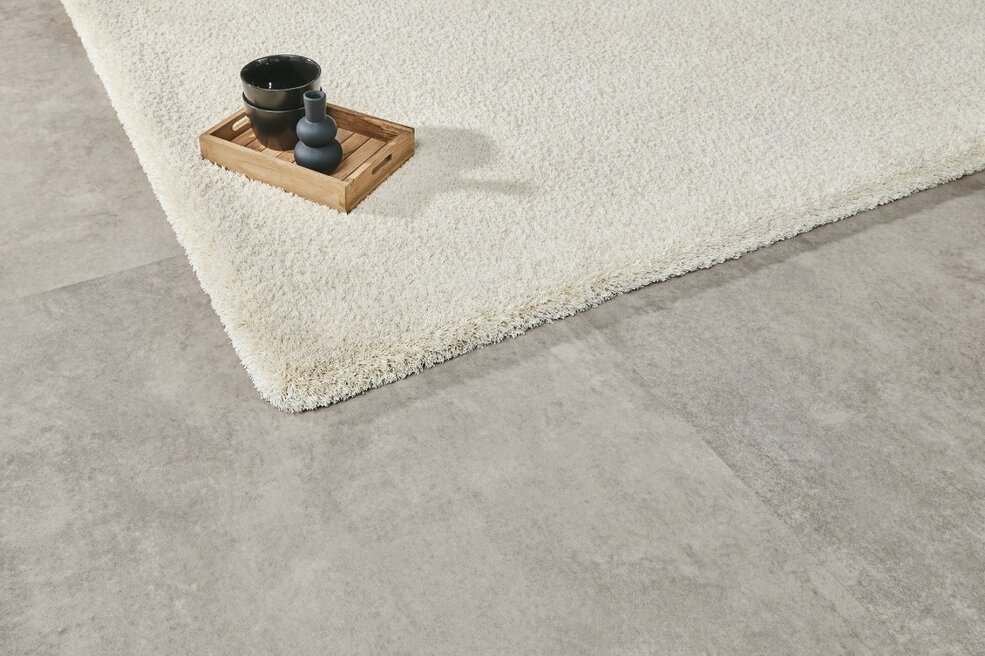JOKA Designboden in moderner Steinoptik kombiniert mit hellem Teppich im Lagom-Stil