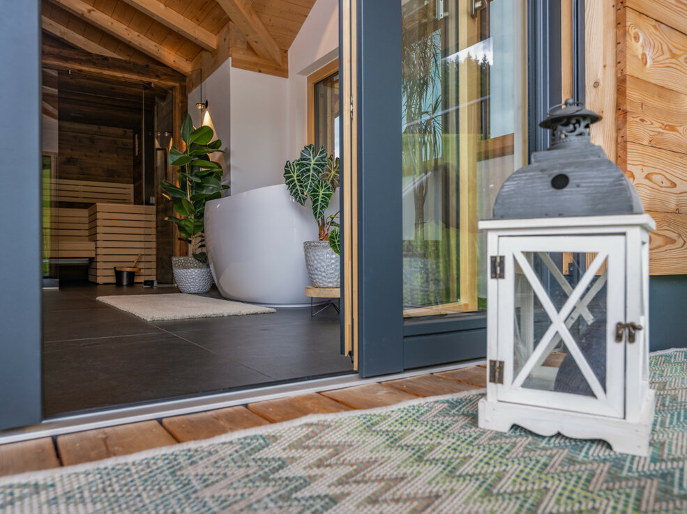 Terrassenblick mit Lampe, der ins Badezimmer führt.