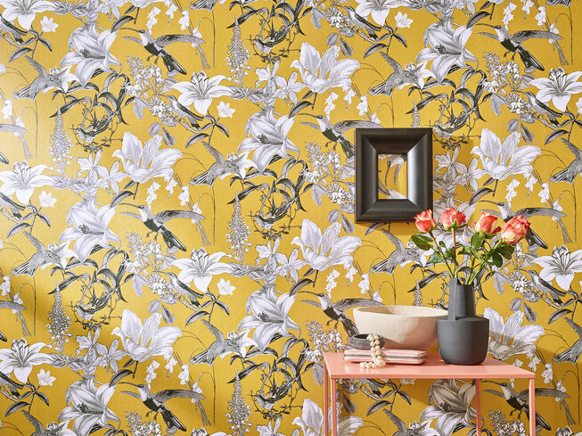 Detailaufnahme der gelben JOKA Tapete mit floralen Mustern – der besondere Blickfang für die Raumgestaltung in der Sonnenlicht Wohnidee.
