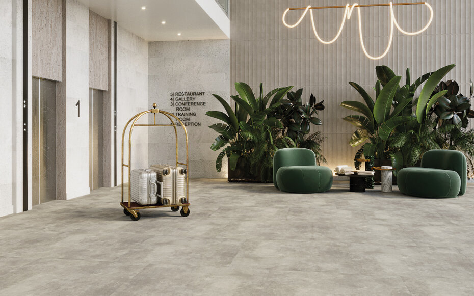 Moderne Hotellobby mit hellgrauem JOKA Designboden in Steinoptik, Pflanzeninseln und luxuriösem Interieur.