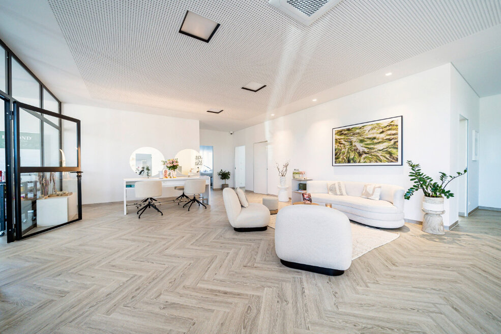 JOKA-Referenzen-Designboden-Beauty-Salon-Fischgrad Raumbild eines hellen Beauty Salons, in dem der JOKA Designboden 555 Cycle im Frischgrad Muster verlegt ist.