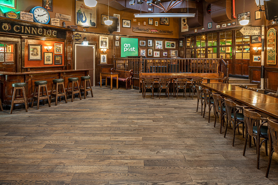 Ein rustikaler Gastraum mit dunklem Holzboden und Holztischen, eingerahmt von traditionellen Dekorationen und rustikalen Holzbalken.