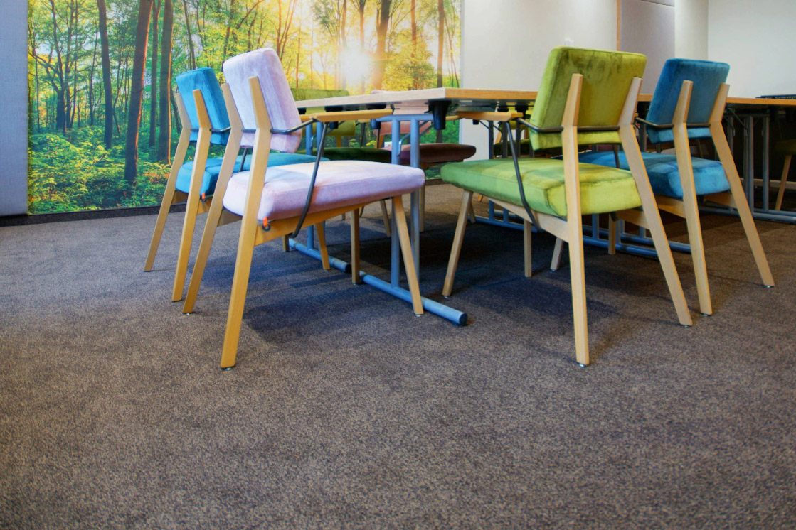 JOKA-Referenzen-Teppich-Hotel-Lounge Detailaufnahme eines Loungebereichs im Hotel, in dem der hellgraue JOKA Teppichboden verlegt ist.