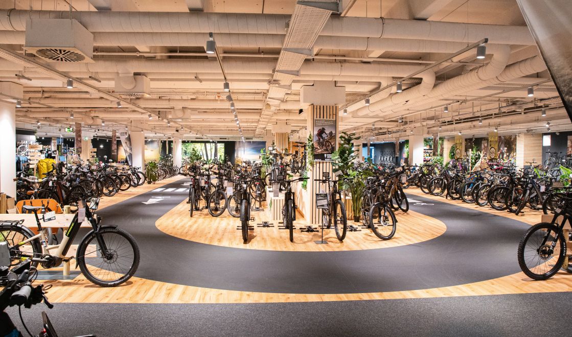 Großzügige Verkaufsfläche im WEKO Einrichtungshaus mit JOKA Designboden und integrierter Fahrradpräsentation.