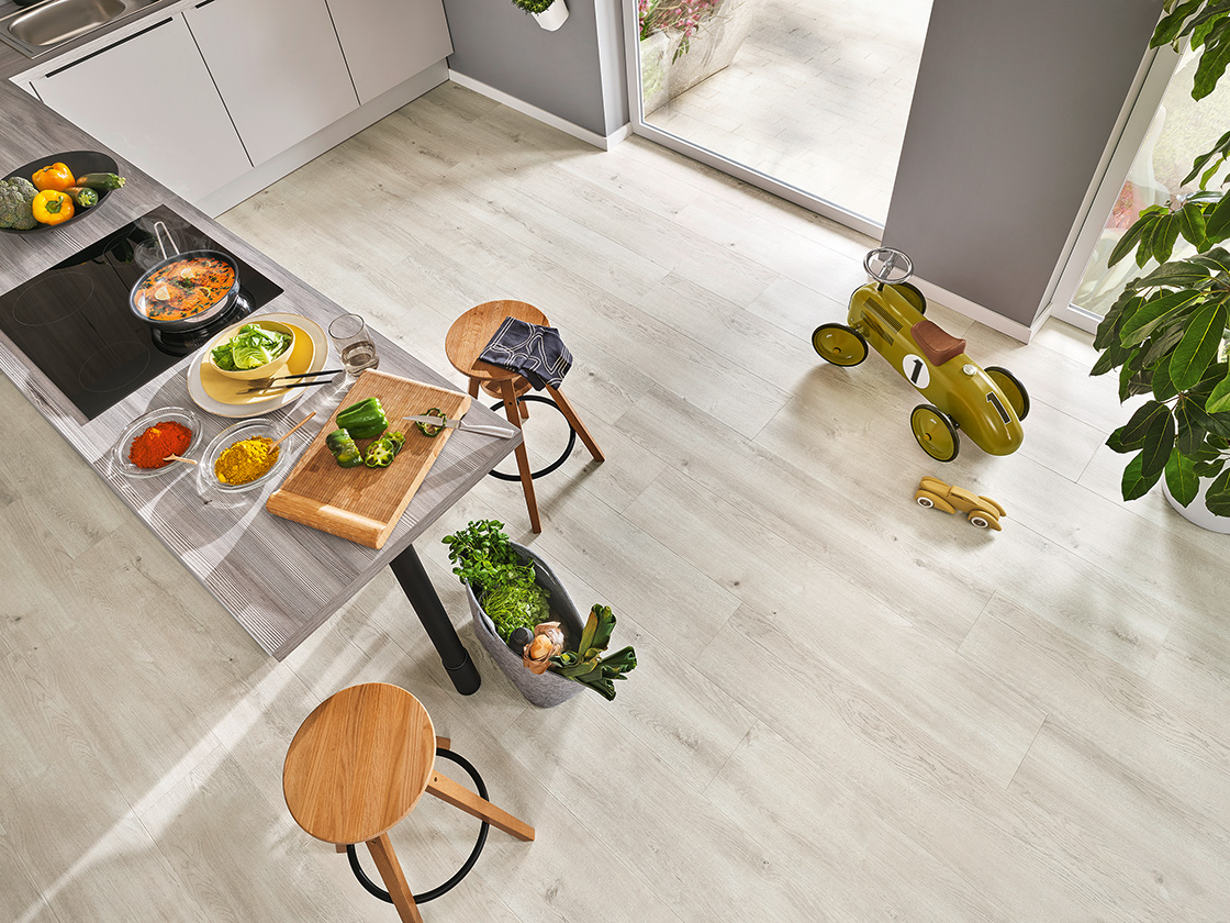 Raumbild einer Küche, in der ein heller, nahezu weißer JOKA Xplora NEXT Naturdesignboden verlegt ist.