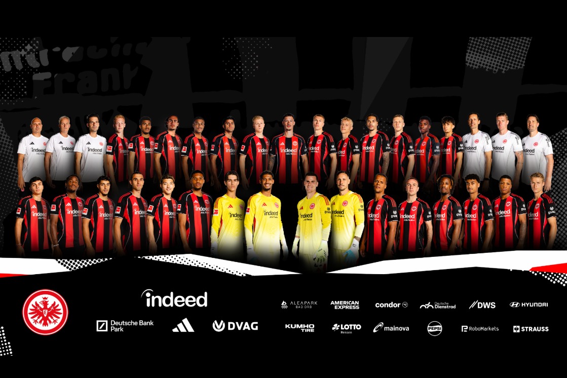 Mannschaftsfoto von Eintracht Frankfurt mit Spielern in Reihe, Eintracht- und JOKA-Logos im unteren Bereich.
