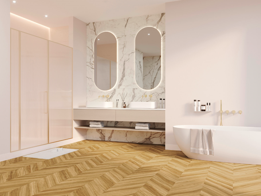 Helles Bad mit JOKA 555 Evolut Fischgrätboden in Amber Oak, eleganter Marmorwand mit Spiegeln und freistehender Wanne.