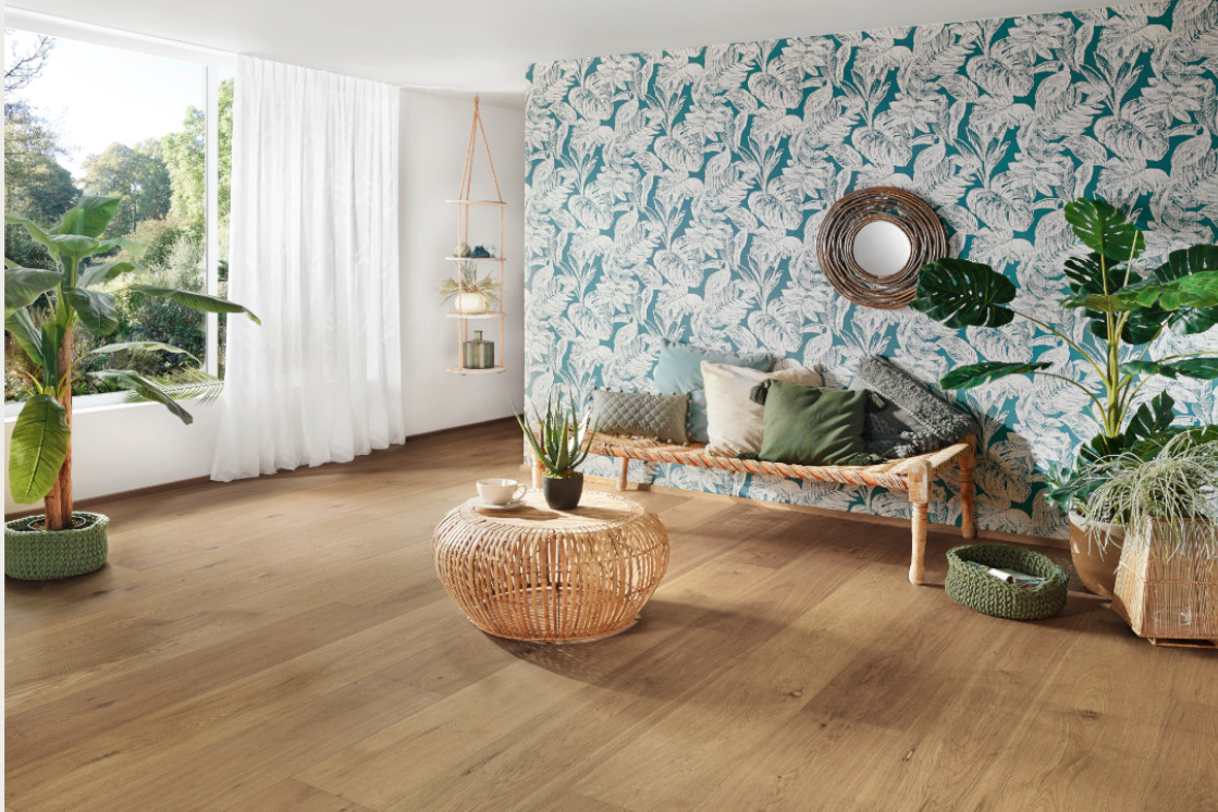 Weitläufiges Wohnzimmer mit JOKA-Bodenbelag und Palmentapete im modernen Tropical-Look.