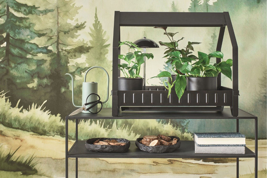 Wandtapete mit grünem Wald- und Landschaftsmotiv hinter einem schwarzen Konsolentisch im JOKA Wohnkonzept Possible Kitchen.