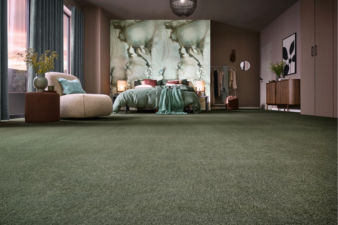 Großzügiges Schlafzimmer mit grünem JOKA Teppichboden, floral gestalteter Wand und harmonisch abgestimmter Einrichtung.