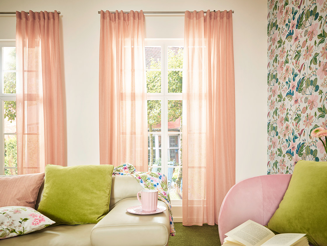 Detailaufnahme einer Fensterfront, die von rosa JOKA Vorhängen abgehangen sind - blickdicht aber lichtdurchlässig.