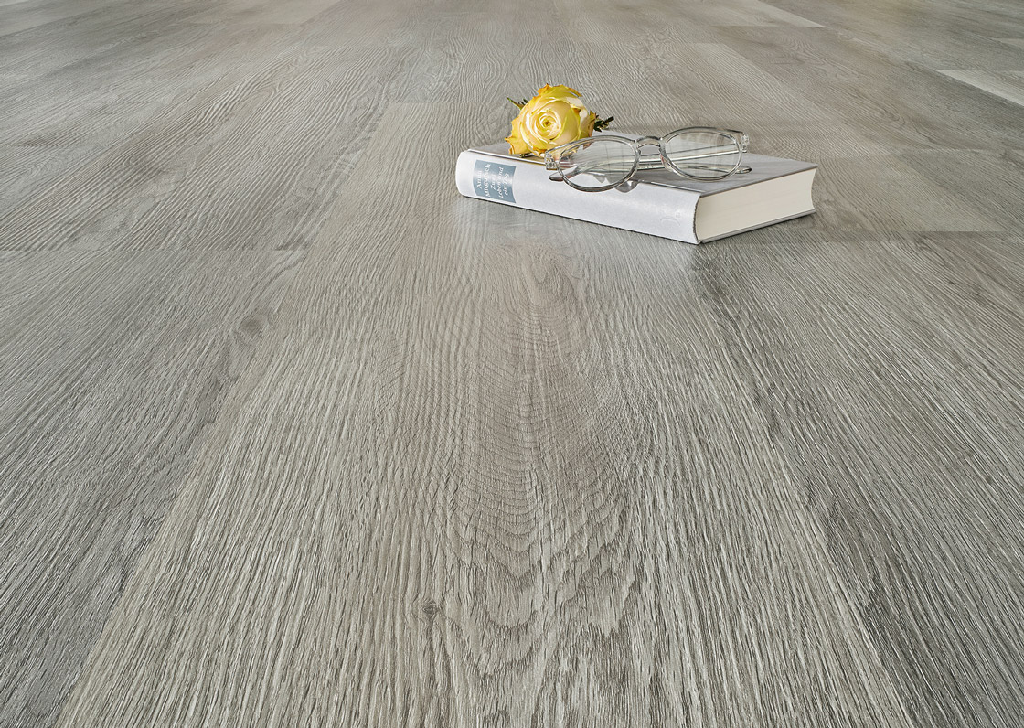 Nahaufnahme des grauen JOKA Sinero Designbodens – der beständige Fußboden für die Raumgestaltung in der Sonnenlicht Wohnidee.
